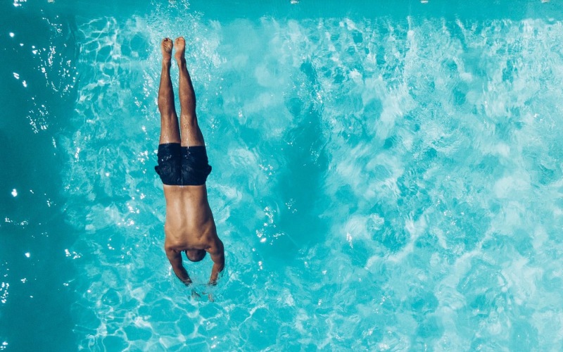 a man diving into a swimming pool
